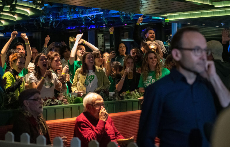May 3rd 2025, Melbourne, Australia. Greens supporters cheer in the background as Greens MP Adam Bandt prepares for a live TV Interview at their election party. Credit: Jay Kogler/Alamy Live News. Image: Alamy Contributor: Jay Kogler / Alamy Stock Photo Image ID: 3B66AEN Gunning for the Greens over Gaza - Part 1