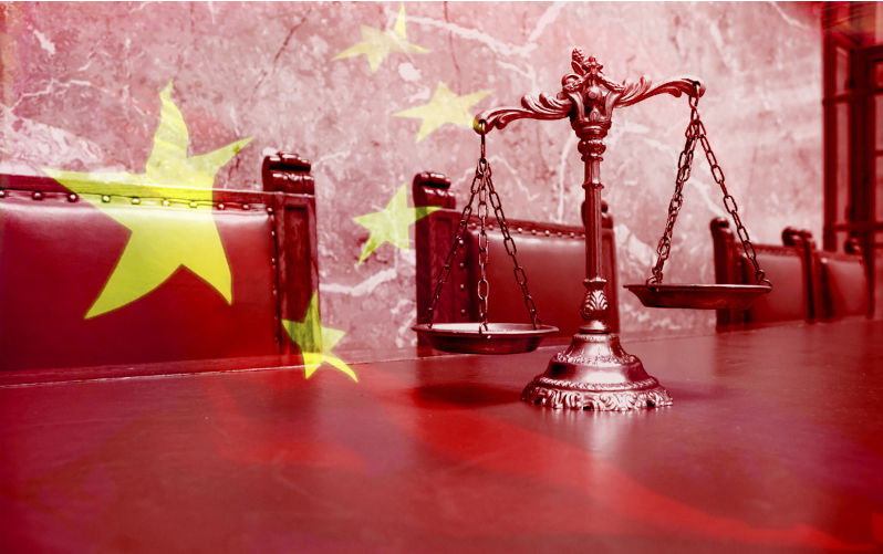 Decorative Scales of Justice on the red table with Chinese flag. Image: iStock / tomloel China touts new law as foundation for private sector growth