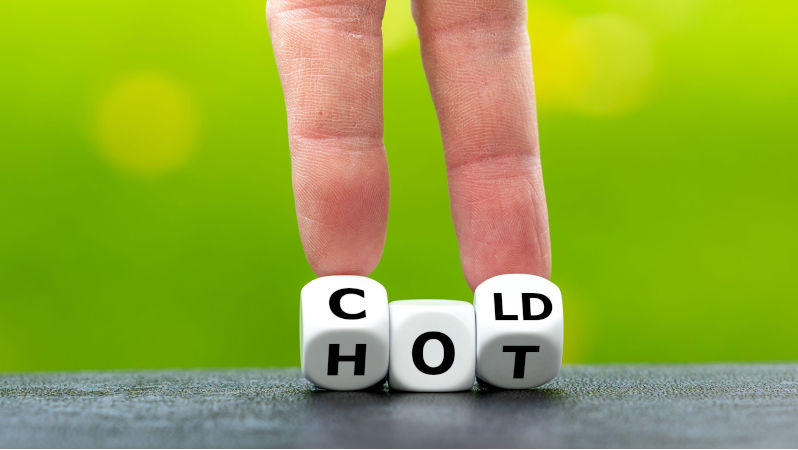 Hand turns dice and changes the word 'hot' to 'cold'. Contributor: Frank Harms / Alamy Stock Photo Image ID: 2DCCJMM Inequality in an age of weather extremes