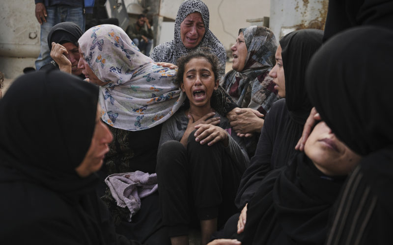 Lian Al-Za'anin, center, is comforted by relatives as she mourns the loss of her father, Rami Al-Za'anin, who was killed while heading to an aid distribution hub, at the morgue of the Shifa Hospital in Gaza City, on Thursday, July 3, 2025. Image: AAP/ AP Photo/Jehad Alshrafi When the helping hand holds a machine gun