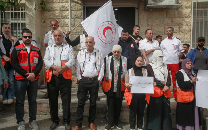 Nablus, Palestine. 23rd Apr, 2025. Palestinian doctors and paramedics from the Palestine Red Crescent Society hold up placards expressing their opinion during a protest. A protest is staged in the West Bank city of Nablus, demanding an international investigation into the fate of those detained by the society during the Gaza war and their release. Credit: SOPA Images Limited/Alamy Live News. Contributor: SOPA Images Limited / Alamy Stock Photo Image ID: 3B00PD6 A monstrous media and murder in Gaza