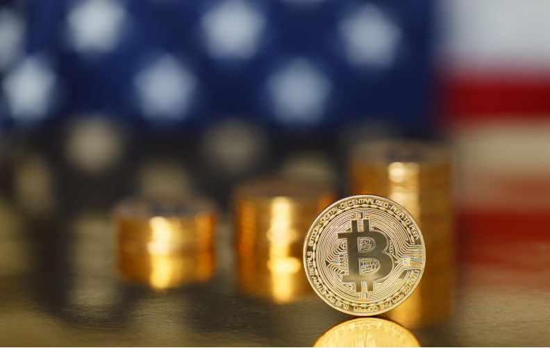 Golden Bitcoin on the flag of USA background. Image: Alamy Contributor: Disabled. man. Image ID: RB20T9 'Greatest corruption in presidential history': Trump family reaps US$5b more in crypto profits