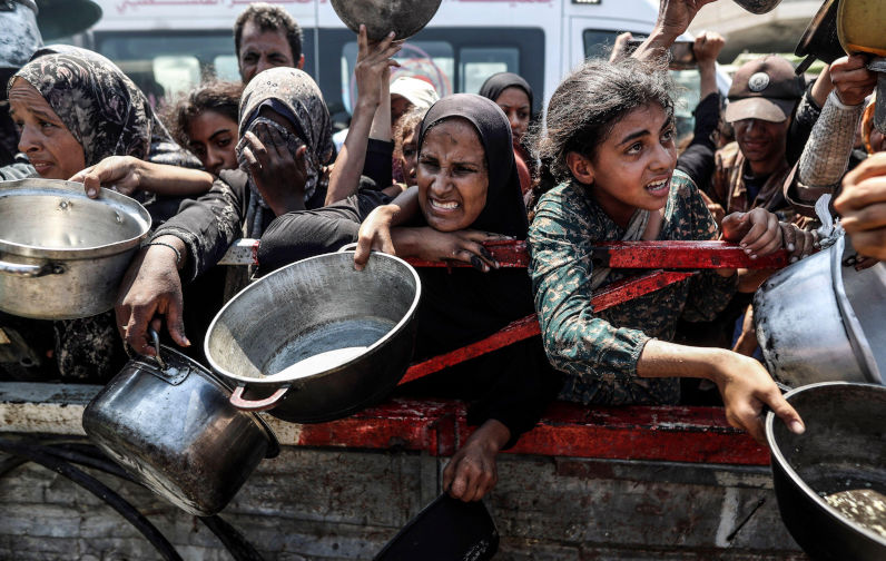 Gaza, 23rd July, 2025. Palestinians crowd to receive a hot meal at a food distribution point in Gaza City, on wednesday on July 23, 2025. Over 100 aid agencies and human rights organisations issued a warning on Wednesday about the growing threat of mass starvation in Gaza, as the United States announced its senior envoy would travel to Europe for talks on a potential ceasefire and humanitarian corridor. Photo by Mahmoud Issa/UPI. Credit: UPI/Alamy Live News. Contributor: UPI Image ID: 3C213WW We are starving