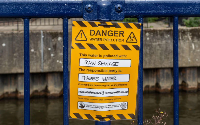 Protest sign reading Danger water pollution, this water is polluted with raw sewage. The responsible party is Thames Water. River Wey, Guildford, UK Contributor: Sam Oaksey / Alamy Stock Photo Image ID: 2RAE8GR Thames Water disaster drags on