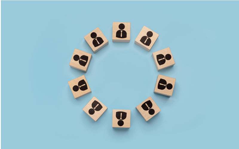 Round table concept, business meeting. businessmen icons on wooden cubes arranged in circle. discussion of important issues, round table talks. pluralism of opinions. Image: iStock / Pavel Muravev Roundtable will fix nothing unless we can all park our self-interest