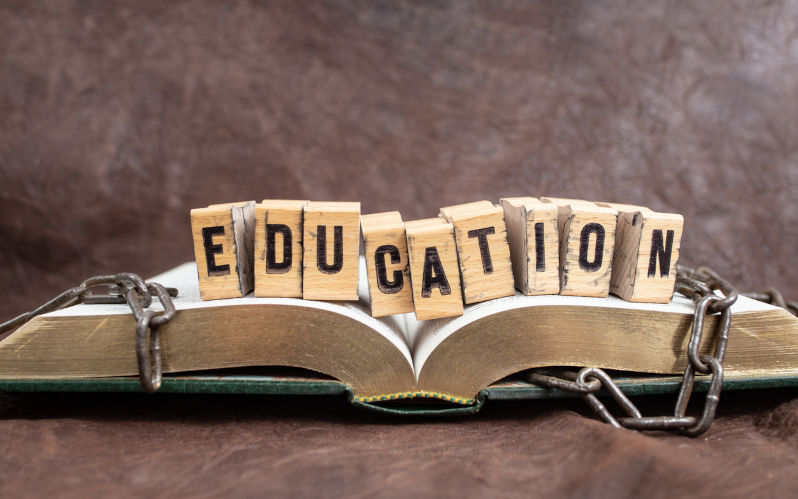 Education word whiten with stamp letters on wood blocks, on a opened book with broken chains, representing education concept. Image: iStock / Dorin Puha Slaying the juggernauts