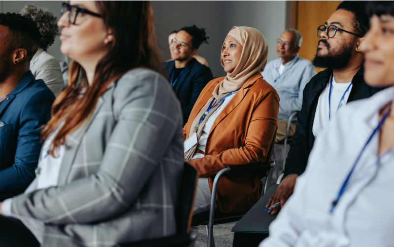 Businesswoman during a conference presentation, surrounded by diverse colleagues. Image iStock / Creditjacoblund The pearling past and the multicultural present: A story of connection and contribution