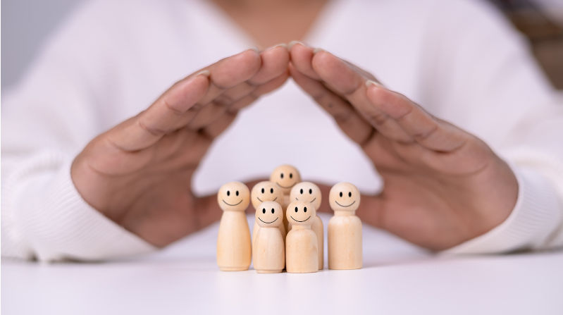 Hand of a person laying down protection a wooden dolls. Image:iStock/Thawatchai-Chawong Australian childcare – do you reap what you sow?