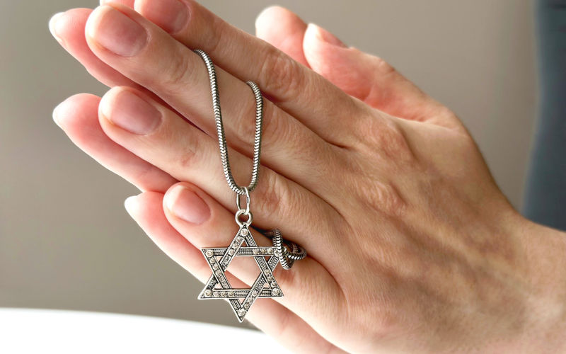 Young woman's Hands praying with david's star silver pendant. Image: iStock / Olena N. Christianity: the antithesis of Zionism