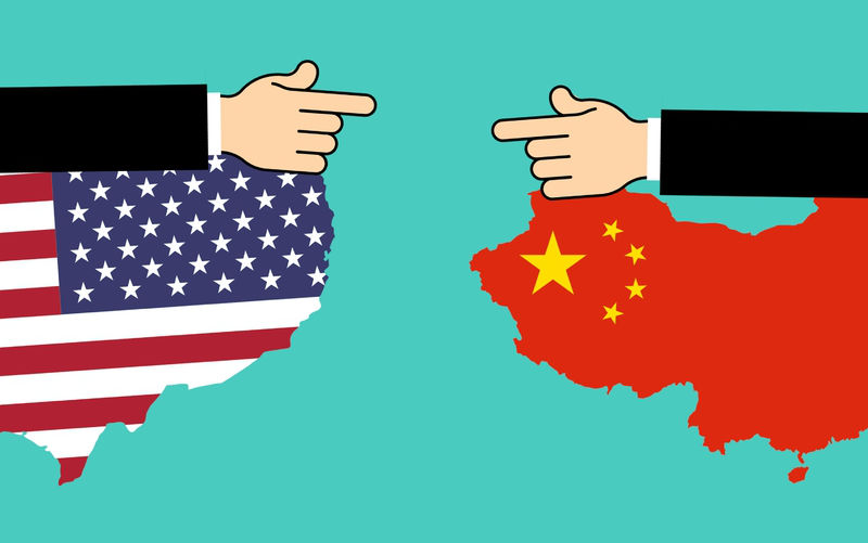 Illustration showing US continent and China both in colours of their flags and two hand that a re pointing at each from each