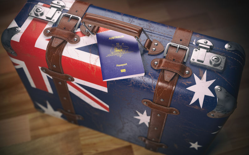 A suitcase painted in the the style of the Australian flag with an Australian passport hooked under the handle