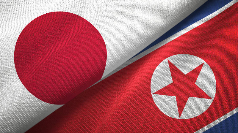 North Korea and Japan two flags together textile cloth, fabric texture