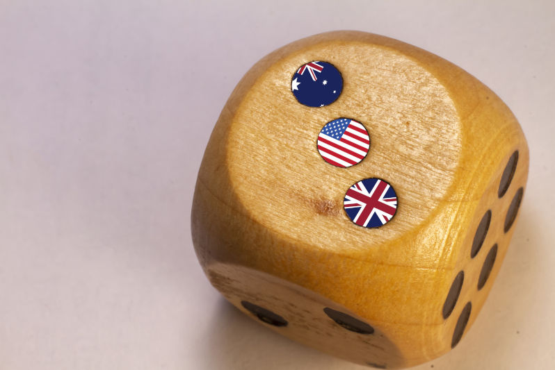 Australia, Uk and USA AUKUS alliance countries flags paint over on wooden dice.