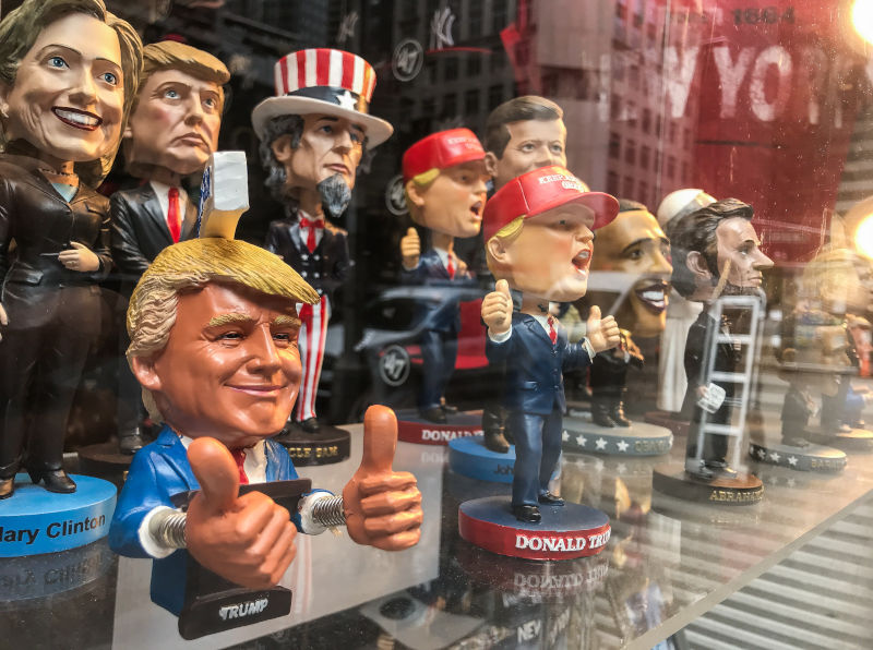 Bobble head dolls of various political figures are seen on a gift shop's window display.