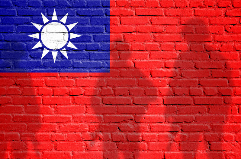 Flag of Taiwan painted on a brick wall with soldiers shadows