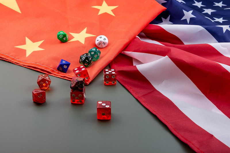 Relations between the United States and China, flags of the United States and China with some red dice on a green table.