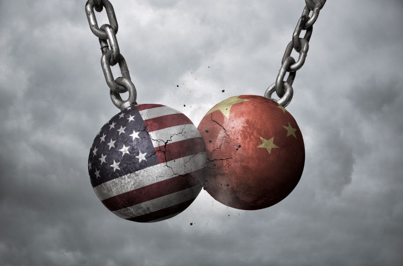 Two wrecking balls with US and Chinese flags hitting each other