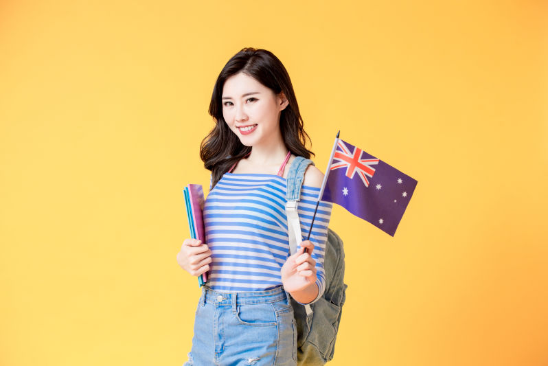 Asian female student smile and look to you with Australian flag