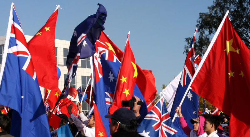 Australia and Chinese flags being waved by Australia and Chinese people