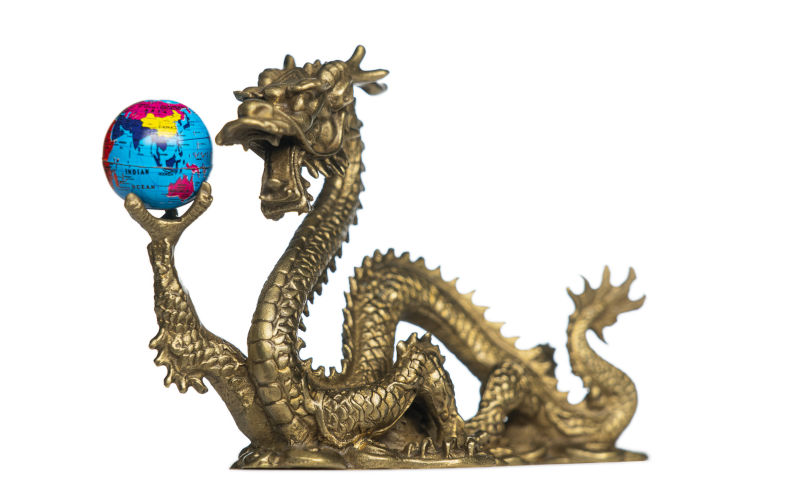 Chinese Dragon holding a globe, turned to Asia and Australia. Isolated on white