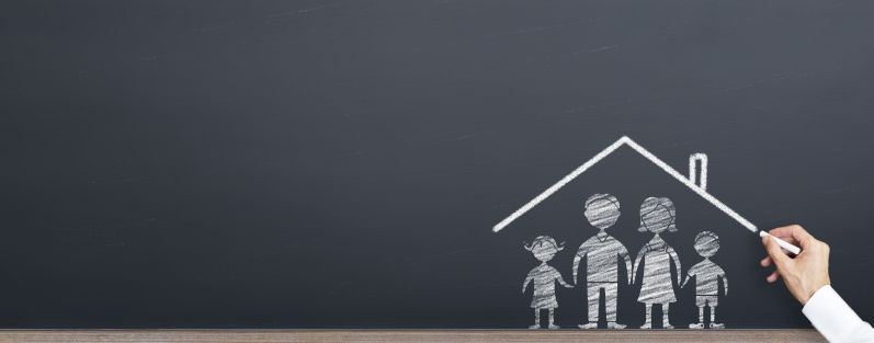 Man is drawing roof on the family on chalkboard. home ownership concept