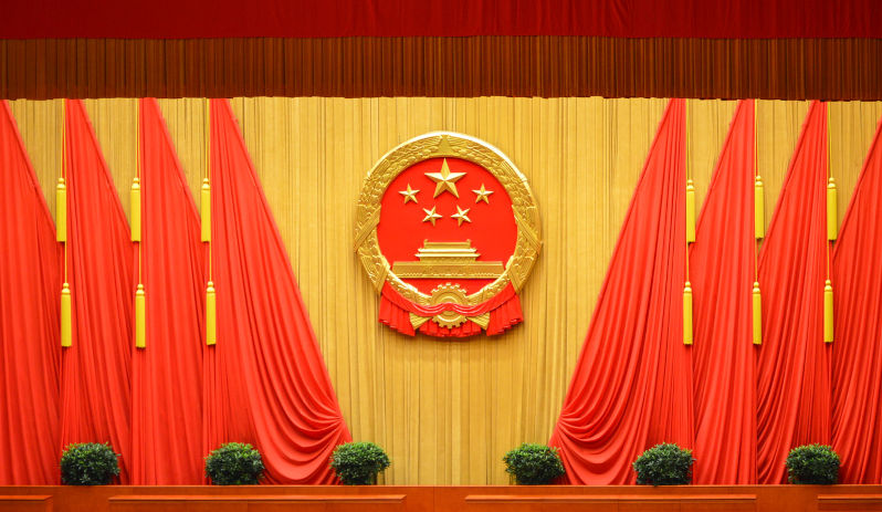 National emblem of the People's Republic of China and Red flags at the Great Hall of the People in Beijing, China