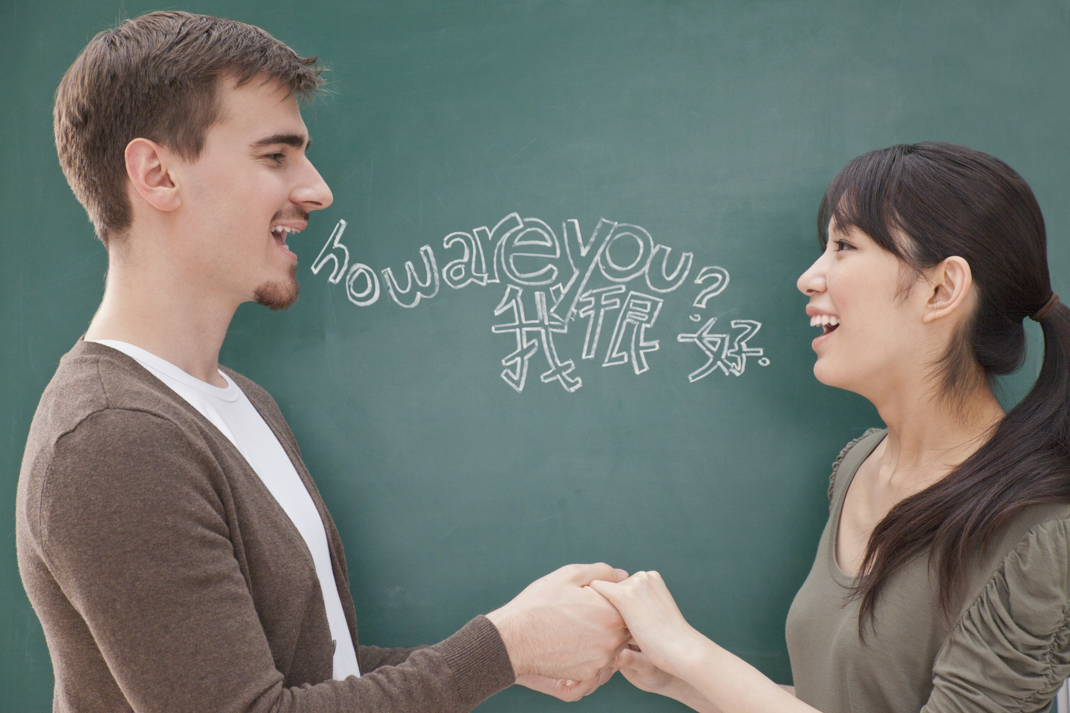 Students in front of chalkboard holding hands