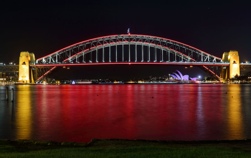 Sydney Harbour Bridge in the colour of red and reflections turn the harbour vivid red too.