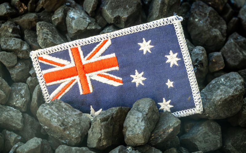 Australian flag on the background of coal, Concept of Coal Mining and Extraction in Australia, Rising commodity prices in the world, Environmental impact, Industry and the economy of the country