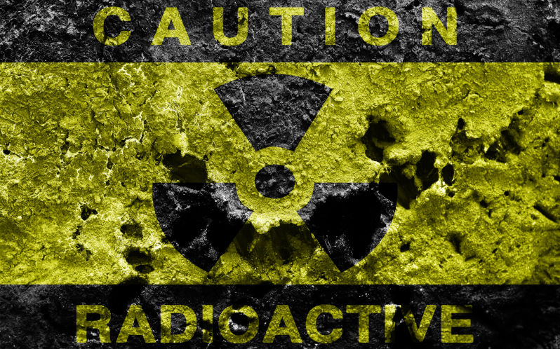 Radioactive sign on old rusty metal barrel