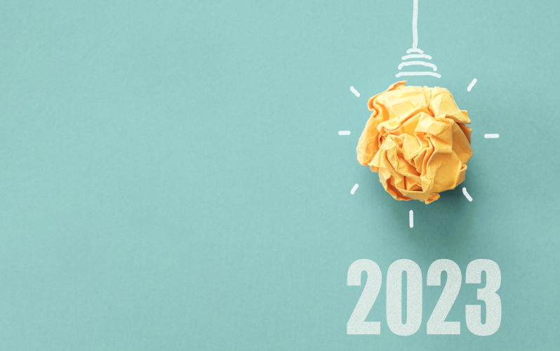 2023 Yellow paper light bulb on blue background.