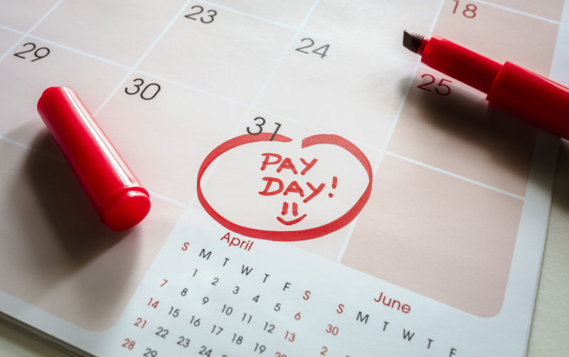 Payday end of month date on calendar with red marker and circled salary day.