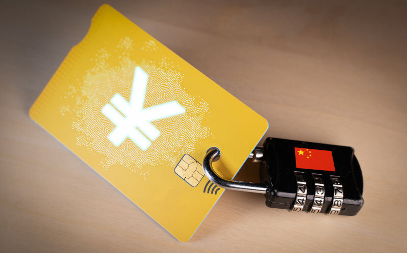 Padlock with Chinese flag and a credit card with yuan digital currency, concept of China digital Renminbi project, online payment, currency security and encryption.