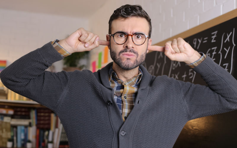 Teacher blocking his ears.