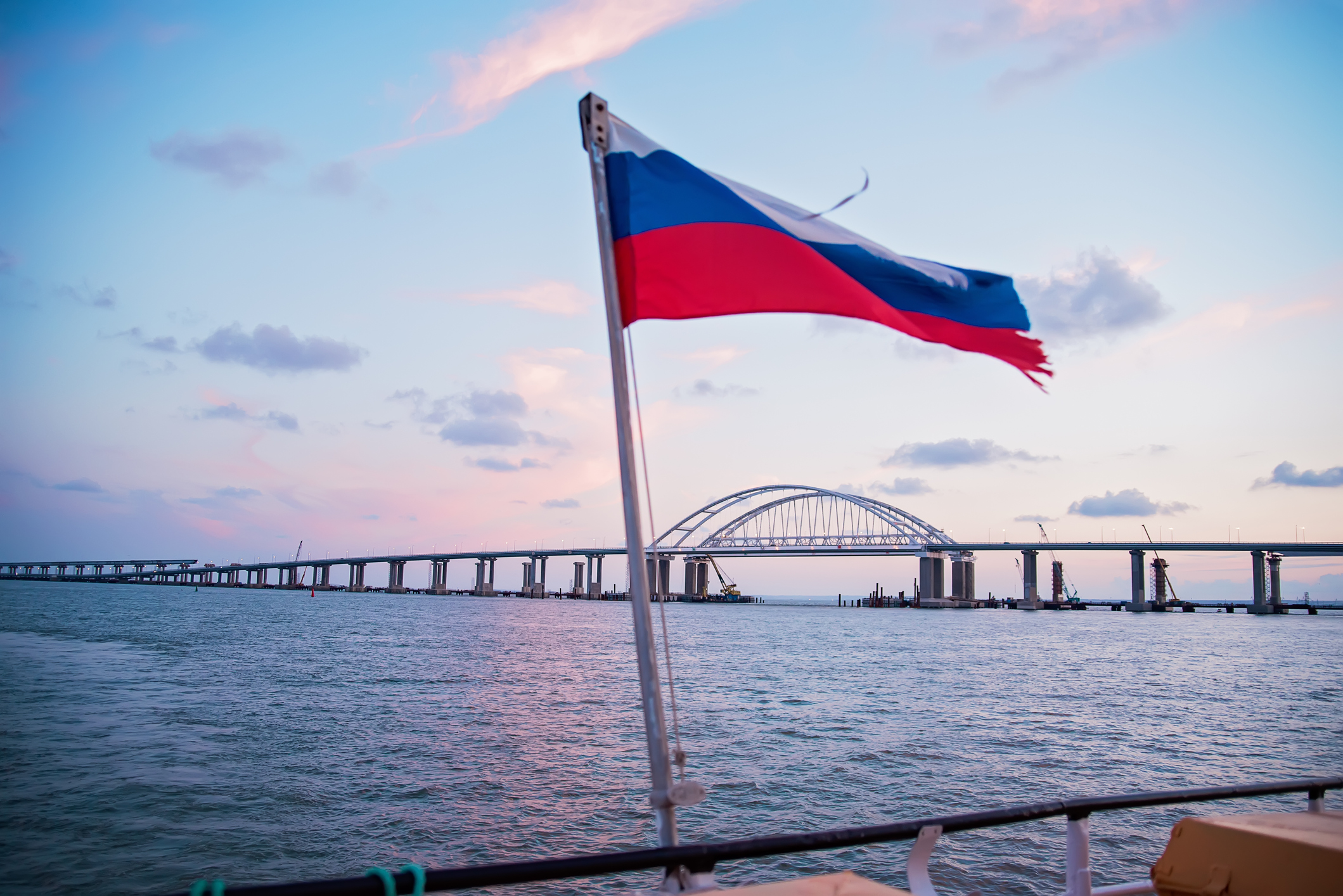 View of the Crimean bridge, from Crimea and the flag of Russia on a yacht, photo from yacht.