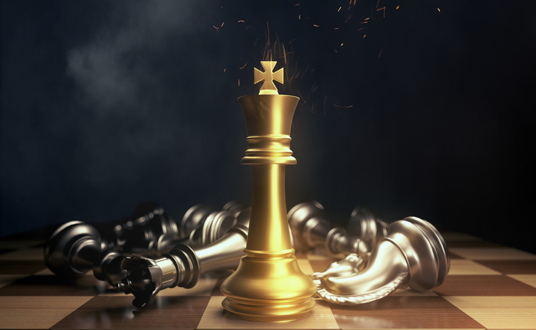 Chess pieces. Gold king winner surrounded with silver chess pieces on chess board game competition. Ultra wealth concept Image: iStock