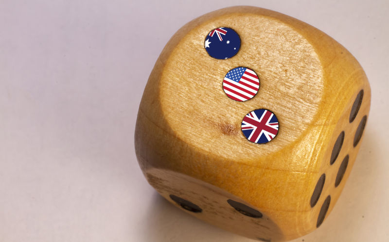 Australia, Uk and USA AUKUS alliance countries flags paint over on wooden dice.