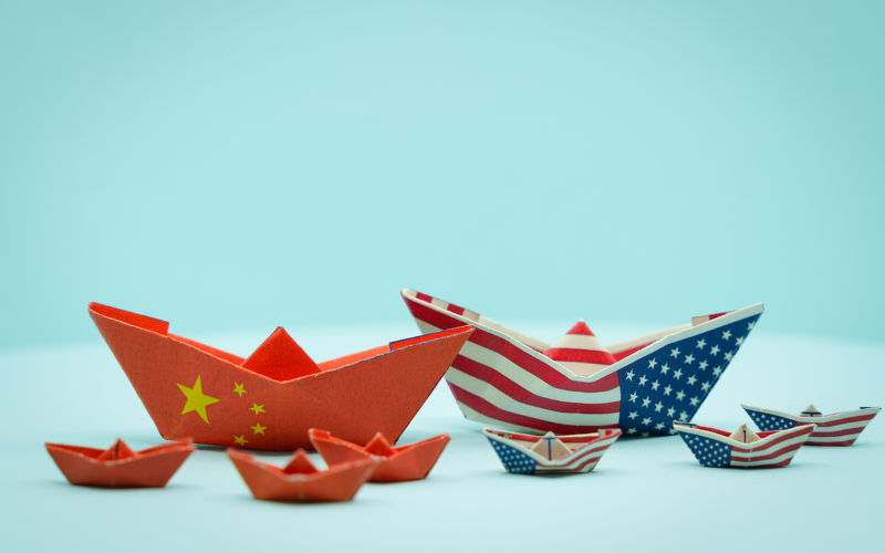 Paper boats with the colours of USA and China facing each other. China and Taiwan war conflict concept. USA and china conflict.