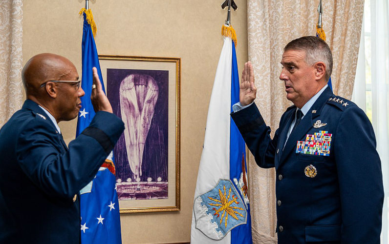 Air Force Chief of Staff Gen. CQ Brown, Jr., administers the Oath of Office to U.S. Air Force Gen. Mike Minihan, Air Mobility Command commander, during his promotion to general at Scott Air Force Base, Illinois, Oct. 5, 2021.