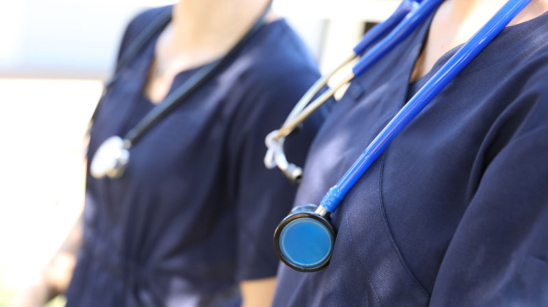 Doctors in blue hospital uniform with stethoscope.