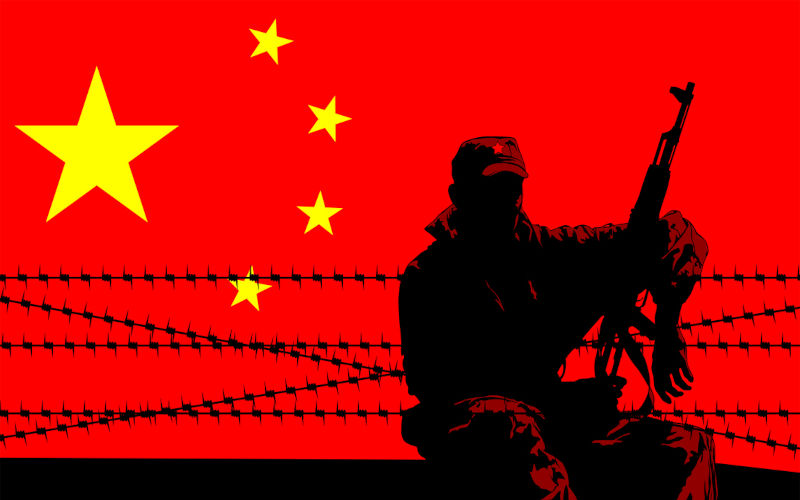 Soldier in protective uniform with machine gun on background of Chinese flag.