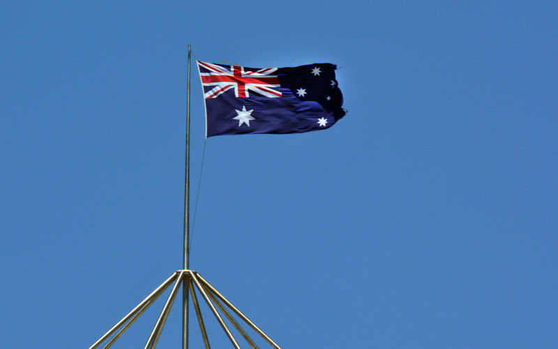 The national flag of Australia fly against blue sky.