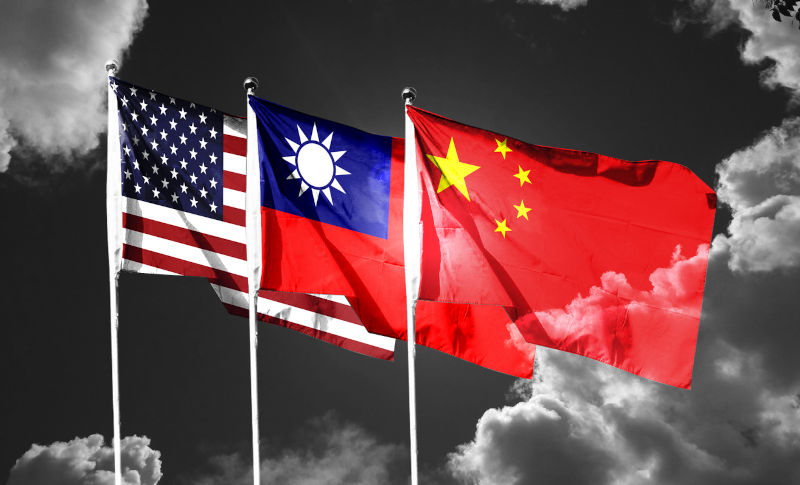 USA and China and Taiwan flags waving in the sky with dark clouds.