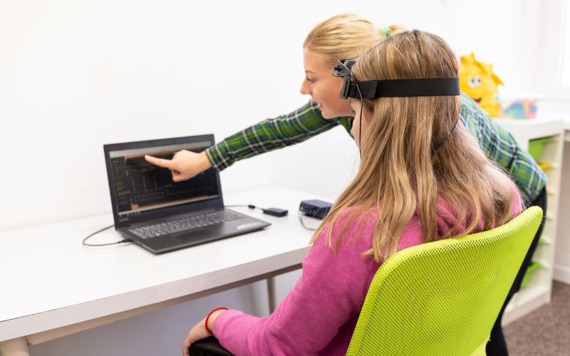 Young teenage girl and child therapist during EEG neurofeedback session. Electroencephalography concept.