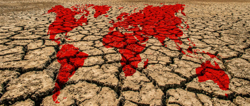 World map on a dried and cracked soil.