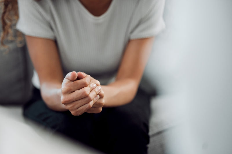 Cropped shot of an unrecognisable woman sitting alone and feeling anxious.