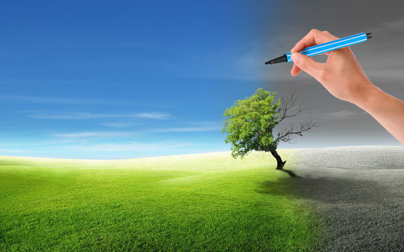 Ecology and Environment Concept : Hand holding blue magic pen and painting green trees and blue sky.