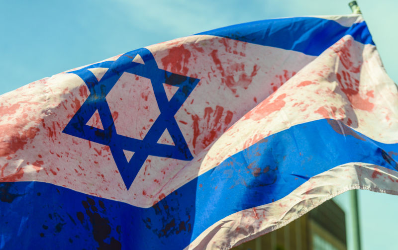 Israeli flag covered in red handprints representing blood of Arabs at an anti-Israel protest.