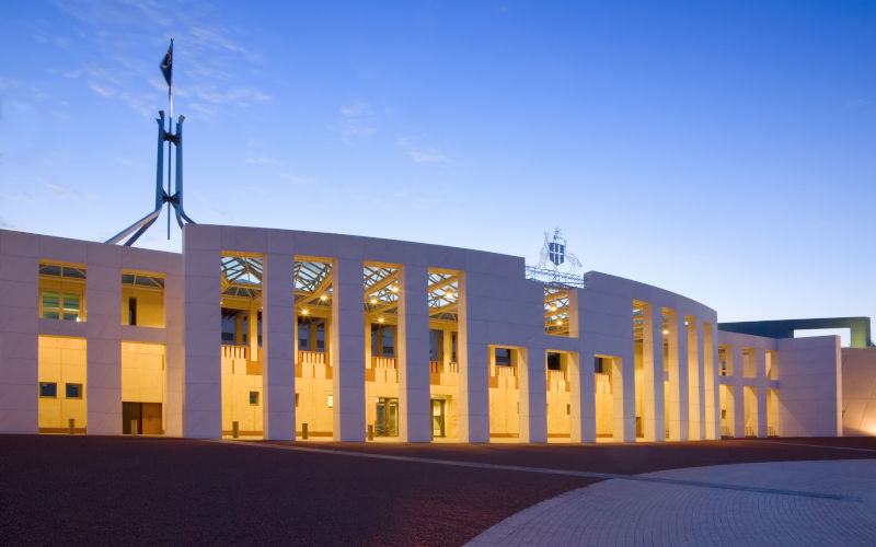 Australian Parliament House illuminated at twilight.