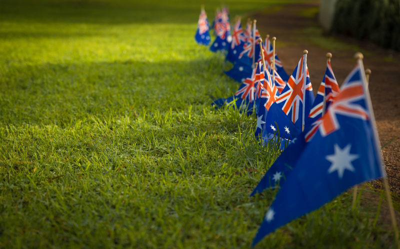 Line of Australian flags along path way in the park. National symbol of celebration Australia or ANZAC Day.